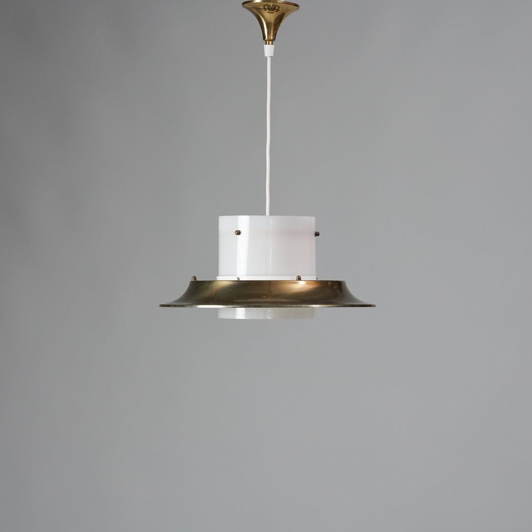 White plastic lamp with a thin brass shade around it. 